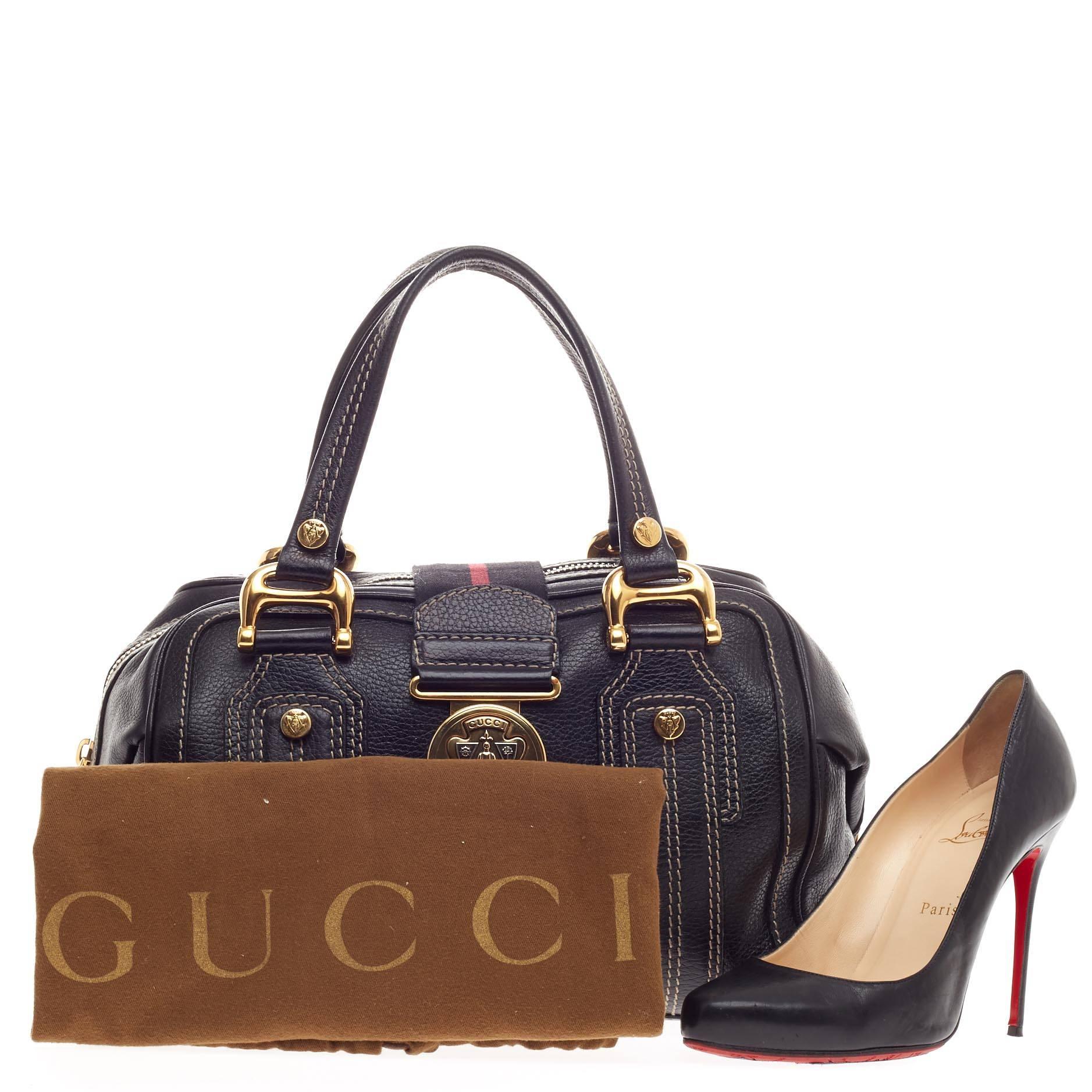 This authentic Gucci Aviatrix Satchel Leather Medium combines functional design with vintage style. Crafted in black pebbled leather, this bag features a striped canvas center panel, dual-flat handles, stand-out beige contrast stitching, protective
