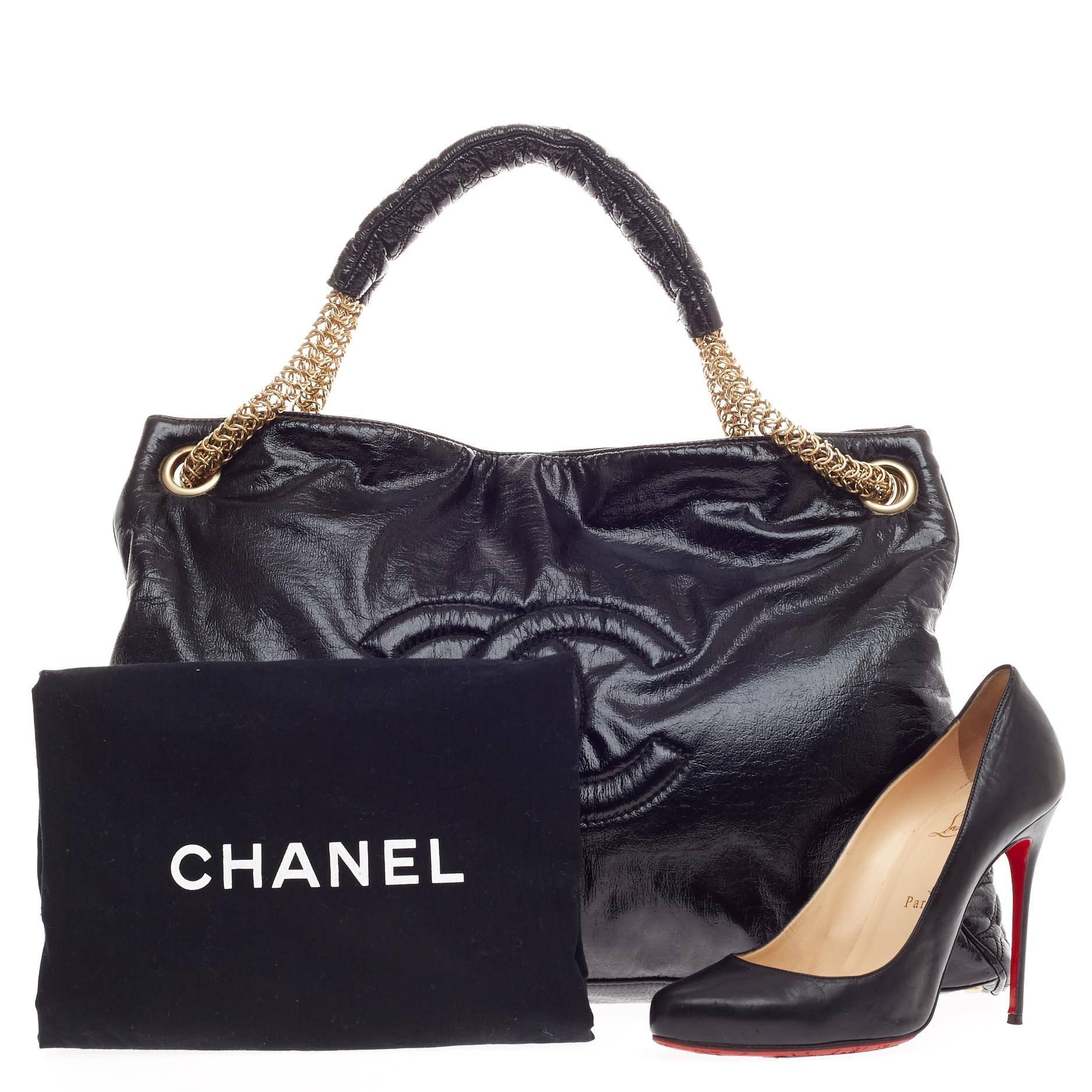 This authentic Chanel Rodeo Drive Tote Patent Vinyl is sophisticated yet classic in design perfect for everyday use. Crafted in distressed black patent vinyl, this oversized tote features dual gold chain handles with pads, oversized CC stitched logo