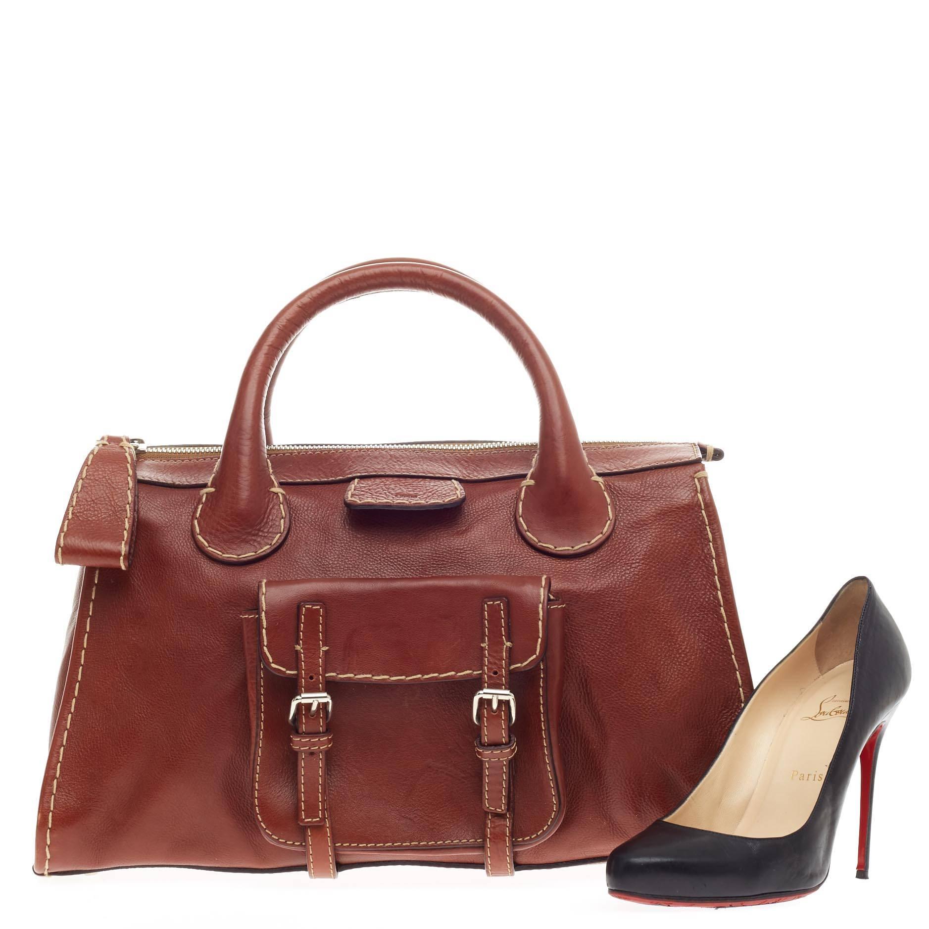 This authentic Chloe Edith Satchel Leather crafted in supple brown leather showcases Chloe's industrially distinct design. This roomy satchel features stylized hand-stitched contrast details, an external front pocket with silver belts and buckles