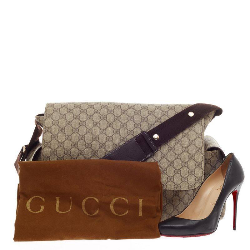 This authentic Gucci Diaper Bag GG Coated Canvas is stylishly made to be carried around everyday holding child's essentials.  Constructed from brown GG monogram coated canvas, this messenger bag features exterior side pockets all with velcro