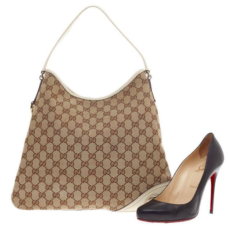 This authentic Gucci New Britt Hobo GG Canvas Medium is perfect for any casual or sophisticated outfit. Constructed with brown Gucci monogram print and white leather trims, this lightweight shoulder bag features a single loop leather strap,