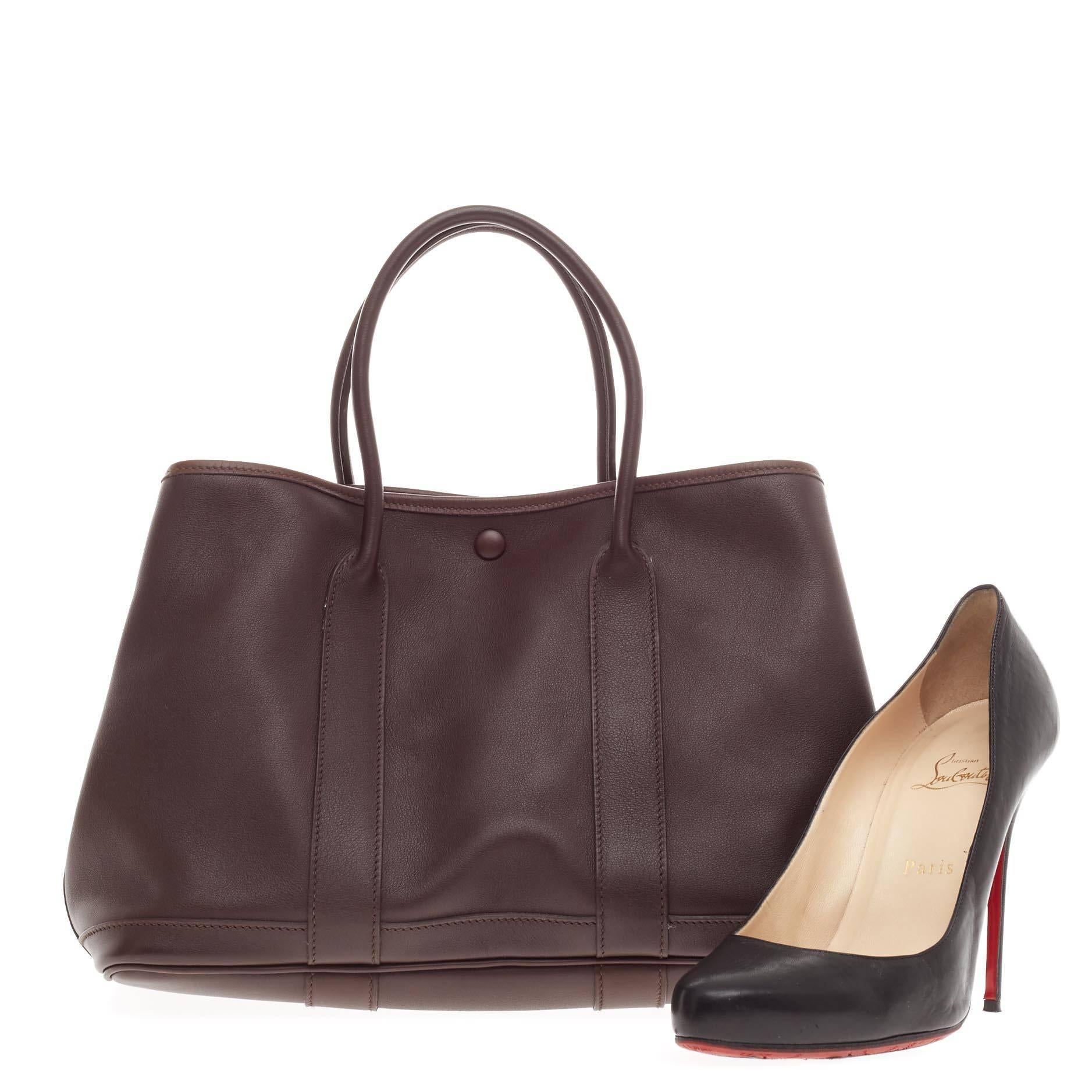 Diese authentische Hermes Bolduc Garden Party Tote Leather TPM ist eine limitierte Auflage einer leichten und dennoch schicken Shopper-Tasche zum Mitnehmen. Diese zierliche Tasche aus dunkelbraunem Swift-Leder verfügt über zwei gerollte Henkel::