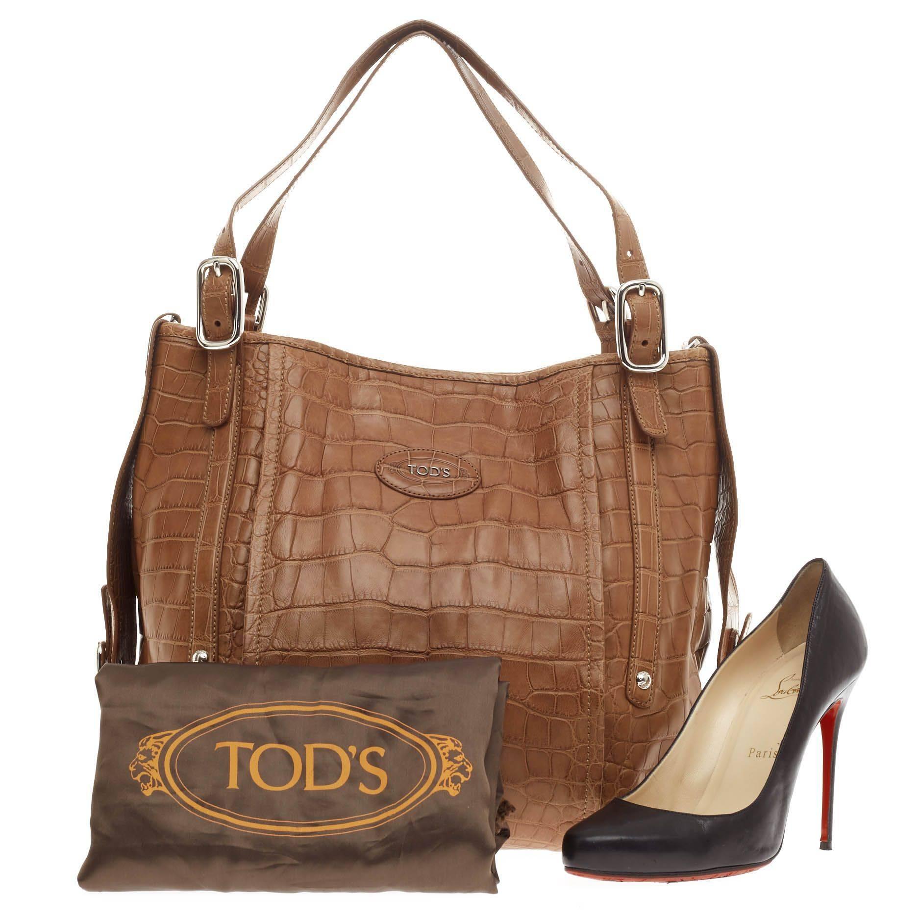 This authentic Tod's G-Bag Sacca Tote Alligator XL released in the brand's 2009 Collection is a luxurious statement piece perfect for everyday. Crafted in sleek genuine brown alligator skin, this Italian-made tote features a simple yet industrial
