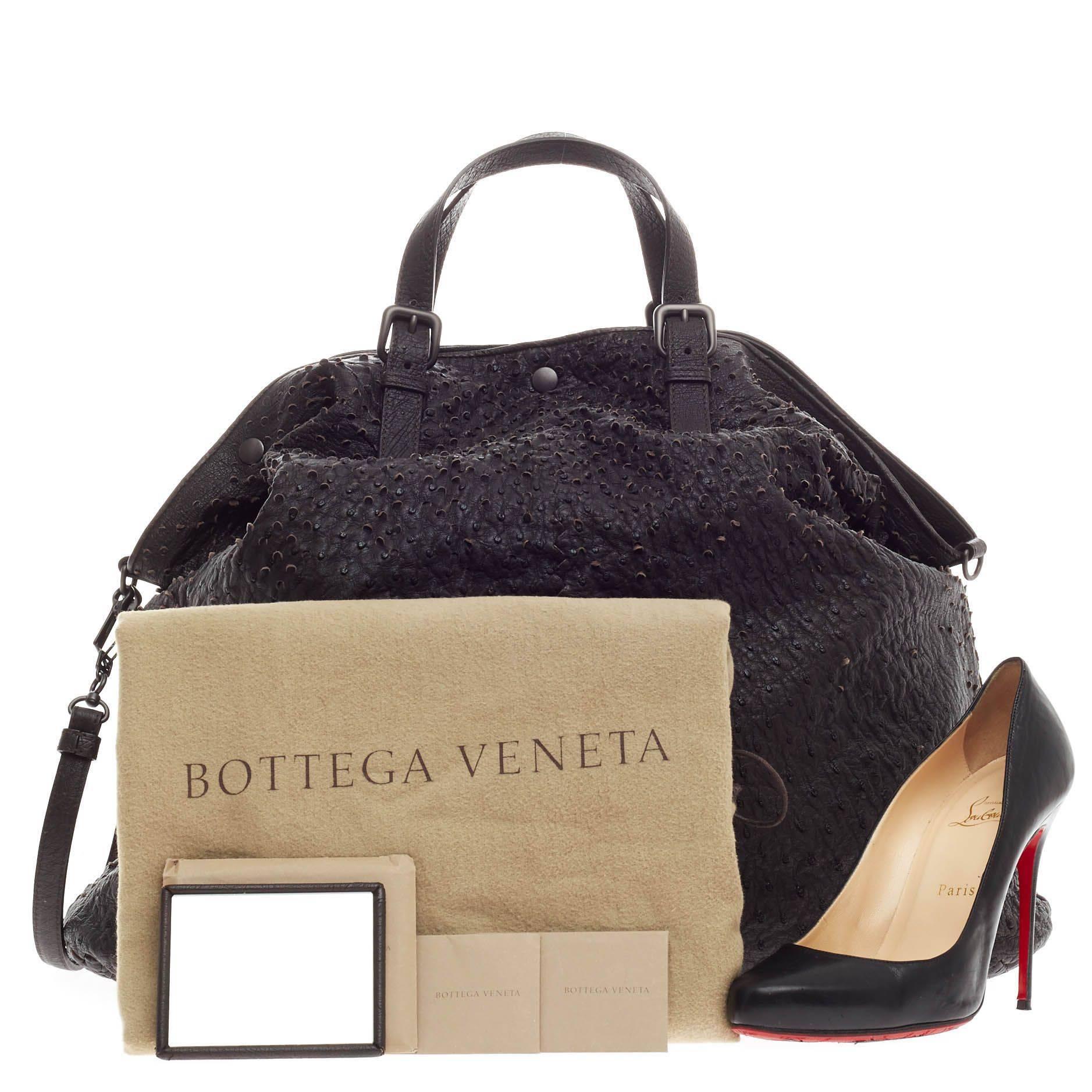 This authentic Bottega Veneta Scaglie Convertible Tote Ostrich with Intrecciato Trim Large is a rare, luxurious, understated tote made for everyday excursions and light traveling. Crafted from ebano dark brown genuine ostrich skin, this oversized