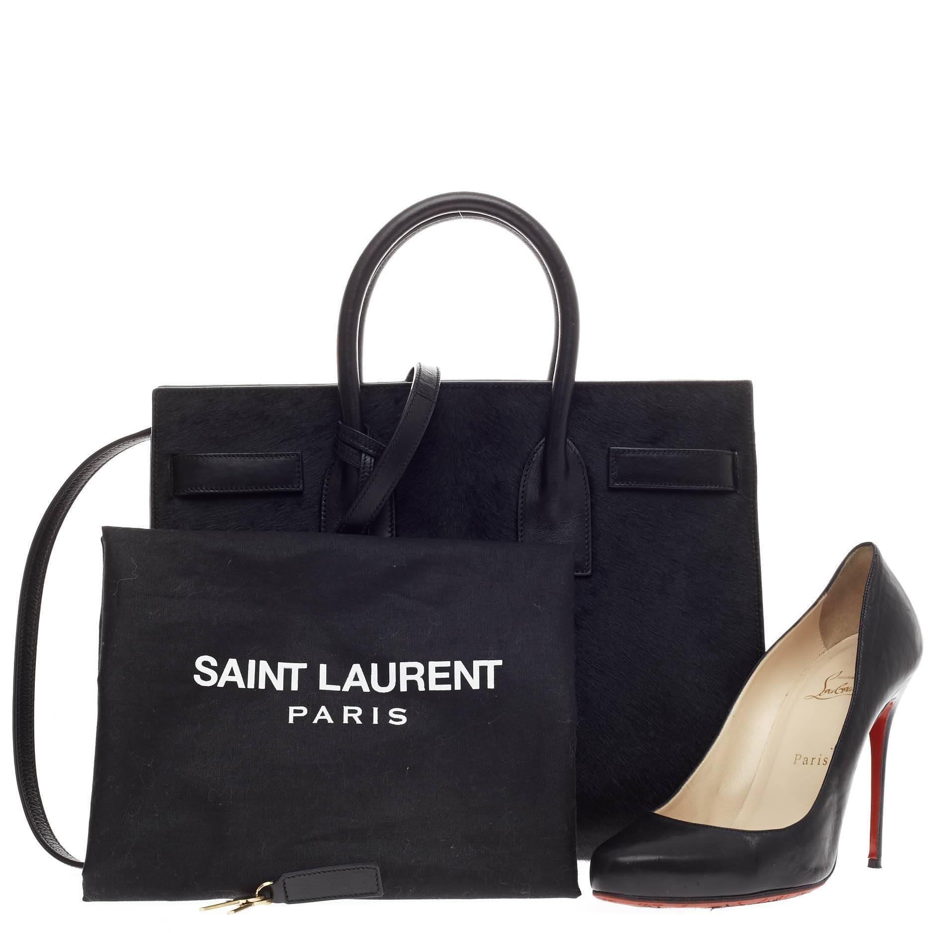 This authentic Saint Laurent Sac De Jour Pony Hair Small  is a sleek yet elegant bag synonymous with the brand's classic aesthetic. Crafted from sleek black pony hair and leather, this sought-out tote features dual-rolled leather handles, leather