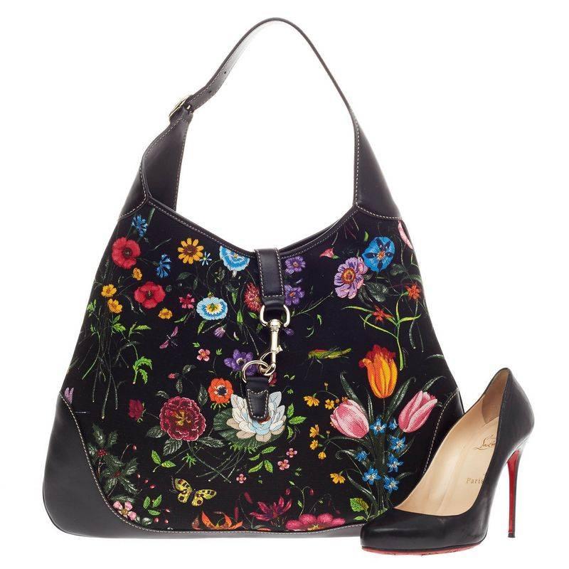 This authentic Gucci Jackie O Flora Canvas Medium is a must-have luxurious everyday hobo fit for the modern woman. Constructed from a beautiful multicolor floral black canvas print with black leather trims, this iconic bag features an adjustable