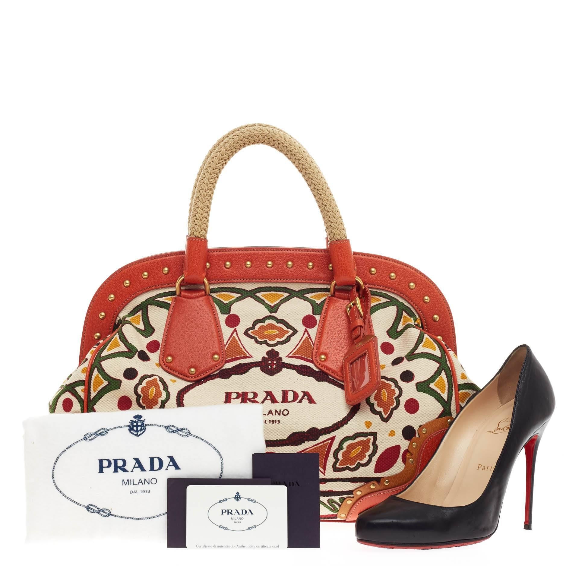 This authentic Prada Canapa Frame Satchel Printed Canvas Medium showcases the brand’s playful side with this vibrant stampata piece. Crafted from white canvas with explosive multicolored prints in orange, green, red and cream, this breezy satchel