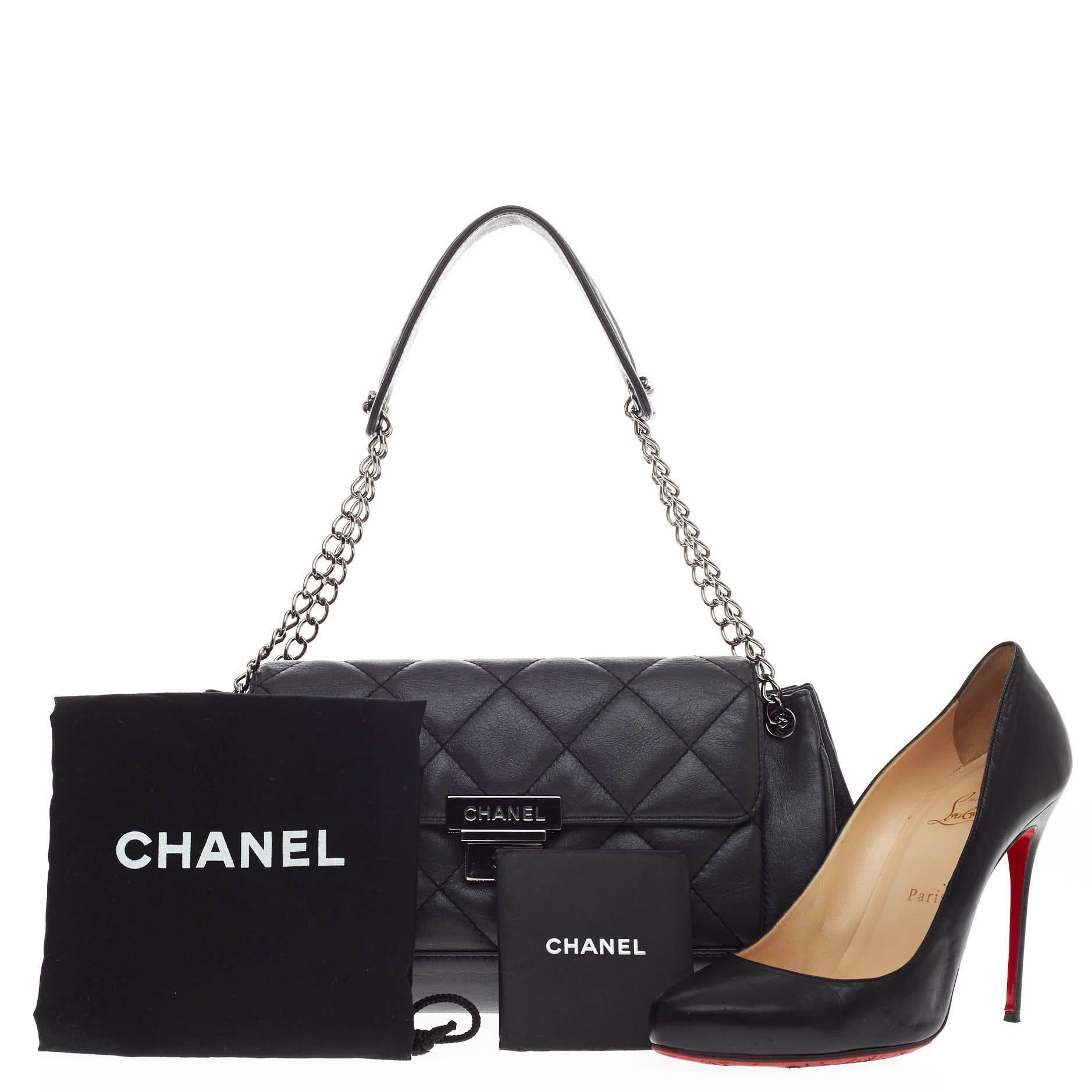 This authentic Chanel Accordion Push Lock Flap Bag Quilted Leather Medium showcases a modern and stylized design with vintage-inspired flair. Crafted from black quilted leather, this elegant shoulder bag features accordion expanded sides, double