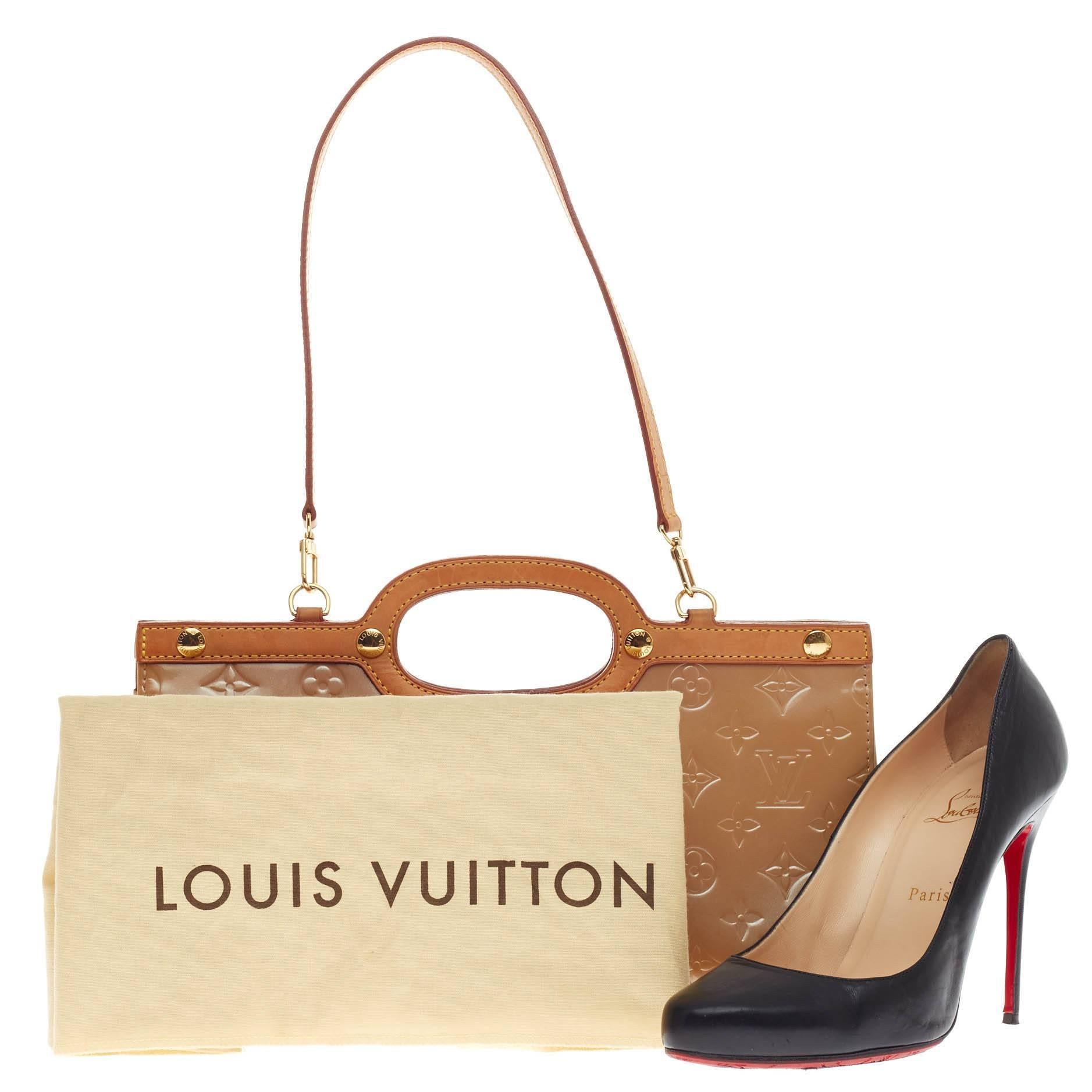 This authentic Louis Vuitton Roxbury Drive Bag Monogram Vernis showcases a unique boxy, triangular silhouette. Constructed from noisette tan patent monogram vernis leather, this bag features flat vachetta leather handles and trims, and gold-tone