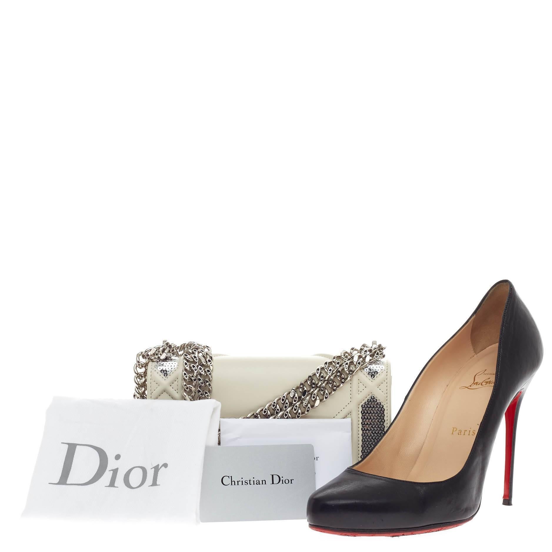 This authentic Christian Dior Diorama Flap Bag Sequin Embellished Lambskin Mini showcases an elegant and unique design that is perfect for night outs. Crafted from off-white smooth leather with silver sequins embellishment, this mini satchel