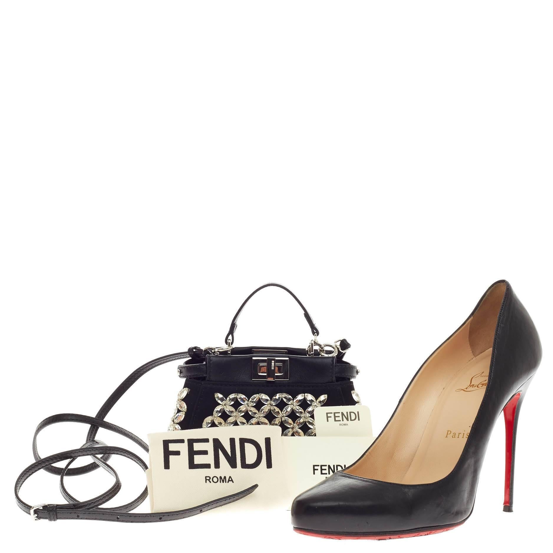 This authentic Fendi Peekaboo Crystal Embellished Satin Micro presented in the brand's 2015 Collection is Fendi's most sought-after design. Crafted from black leather adorned silver crystal embellishment, this micro-size satchel is accented with a