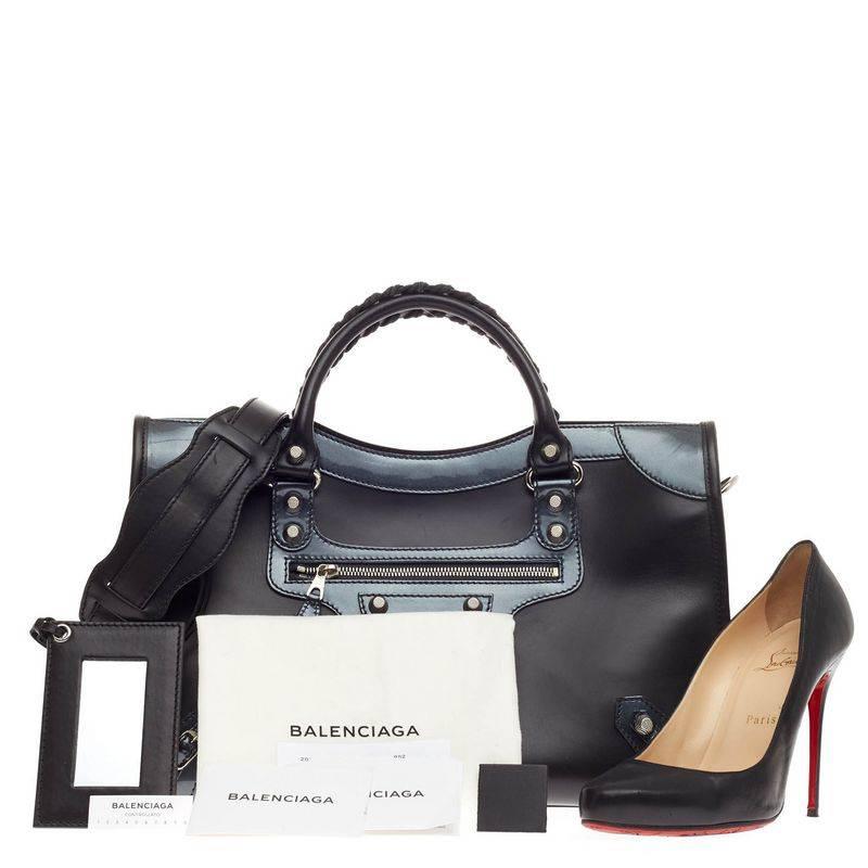 This authentic Balenciaga Holiday City Giant Studs Matte Calfskin Medium presented in designer Alexander Wang's 2015 Holiday Collection takes on a sporty twist. Constructed from structured black matte calfskin leather with dark blue sheen patent