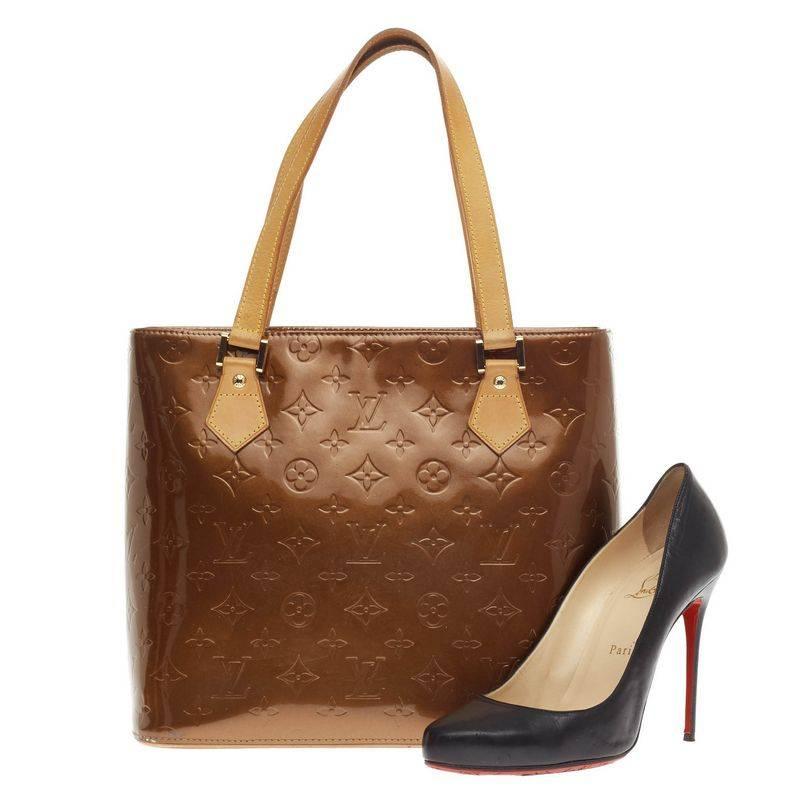 This authentic Louis Vuitton Houston Tote Monogram Vernis is a stylish and functional bag made for everyday use or weekend getaways. Crafted from bronze monogram embossed vernis leather, this tote features dual flat tall vachetta leather handles,
