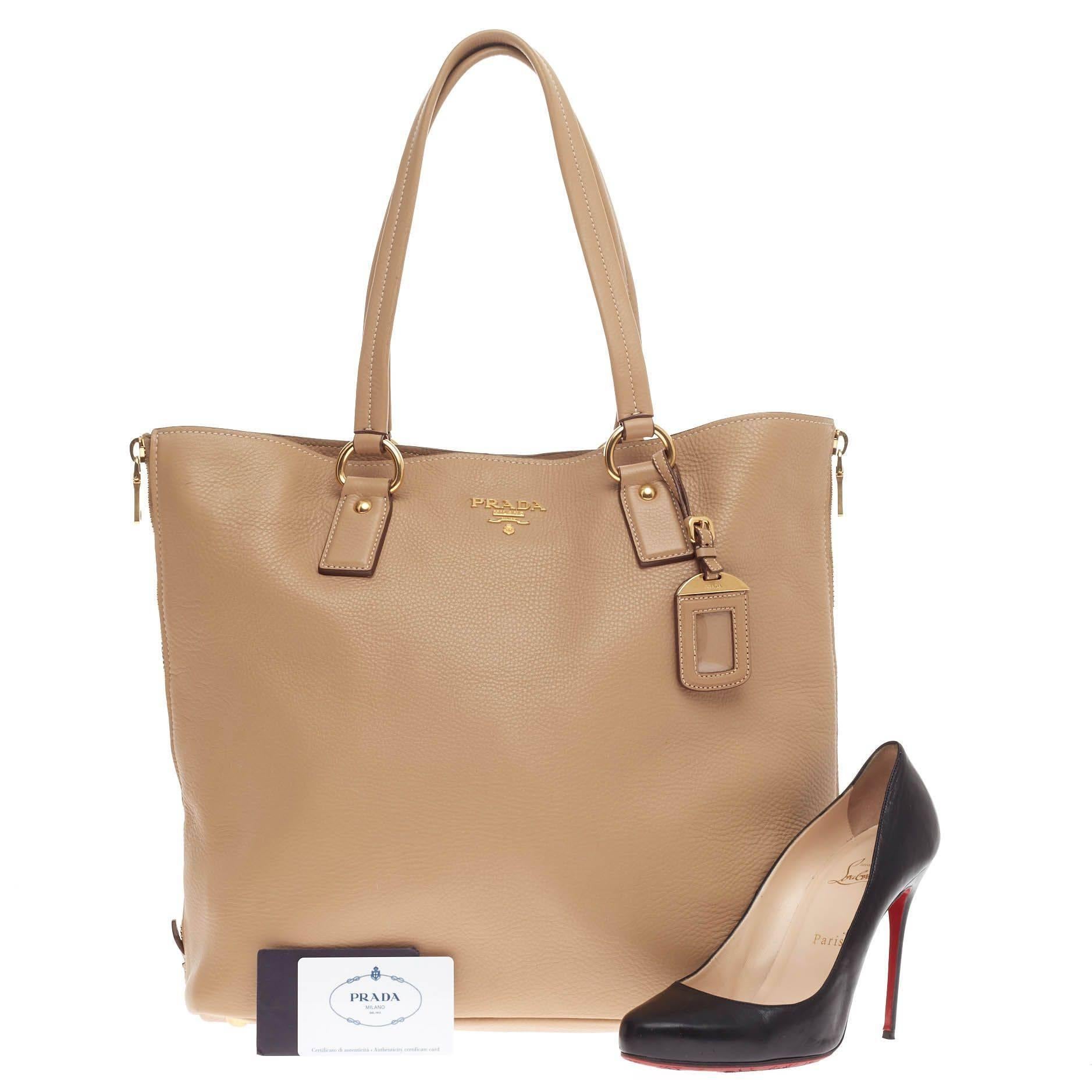 Diese authentische Prada Side Zip Shopper Tote Vitello Daino Large strahlt ein stilvolles und industrielles Design aus:: das für alltägliche Ausflüge gemacht ist. Diese Shopper-Tasche aus sandbraunem Vitello-Daino-Leder verfügt über zwei hohe::