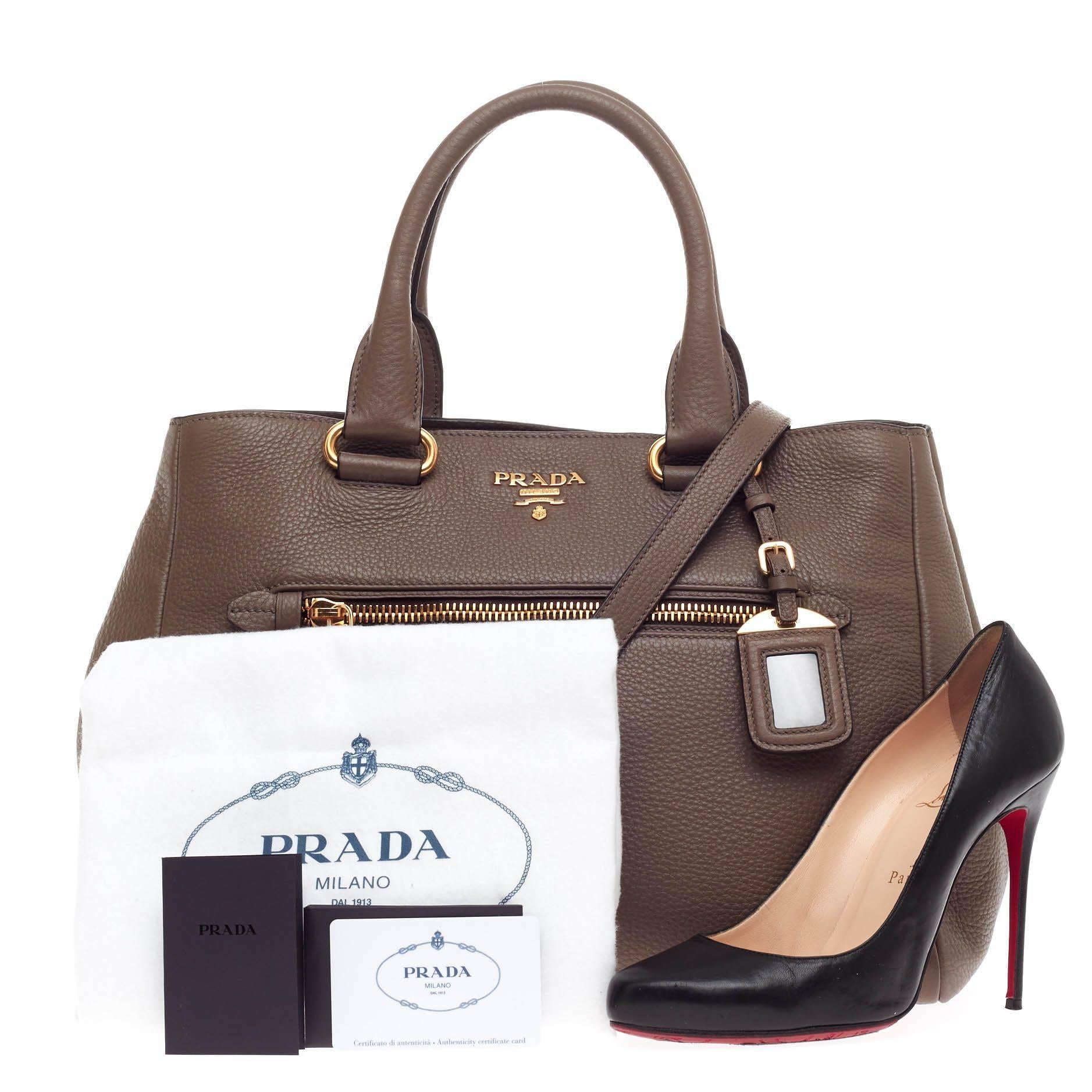 This authentic Prada Front Pocket Convertible Tote Vitello Daino Medium exudes a stylish and industrial design made for everyday excursions. Crafted from bambu taupe vitello daino leather, this tote features dual-rolled leather handles, front zip