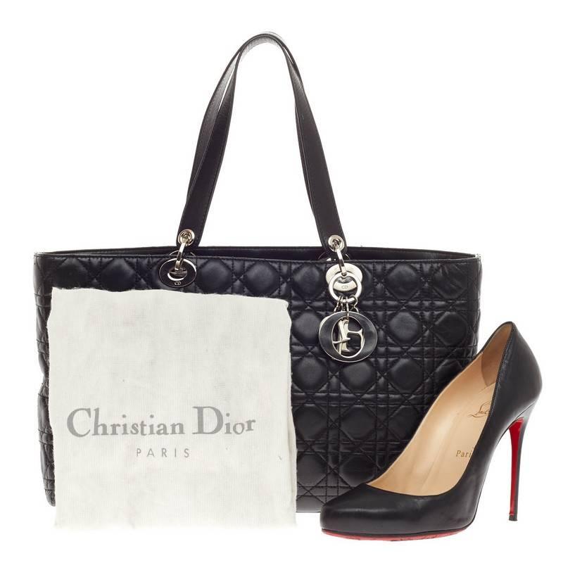 This authentic Christian Dior Lady Dior Tote Cannage Quilt Lambskin Large is a classic staple that every fashionista needs in her wardrobe. Crafted from black cannage quilted lambskin leather, this boxy tote features dual flat handles with sleek