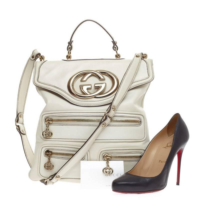 This authentic Gucci Britt Messenger Leather is perfect for daring fashionistas. Crafted from off-white leather, this eye-catching elongated flat messenger features gold-tone hardware accents, oversized Gucci emblem, three front zipped pockets, top