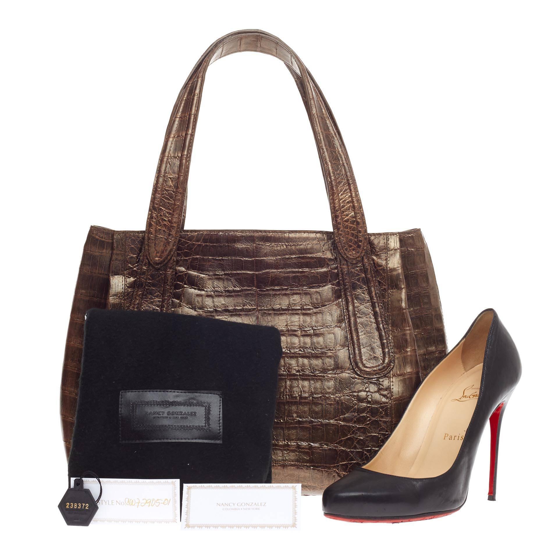 This authentic Nancy Gonzalez Tote Crocodile Medium showcases a perfect polished look made for daily or work excursions. Crafted from metallic bronze genuine crocodile skin, this simple yet elegant tote features dual tall handles, protective base