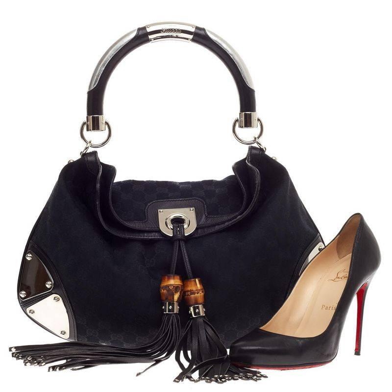 This authentic Gucci Indy Hobo GG Canvas Medium showcases the brand's classic design with luxurious detailing adding an industrial chic twist. Crafted from black GG canvas, this hobo features leather tassels with bamboo hardware accents, silver-tone
