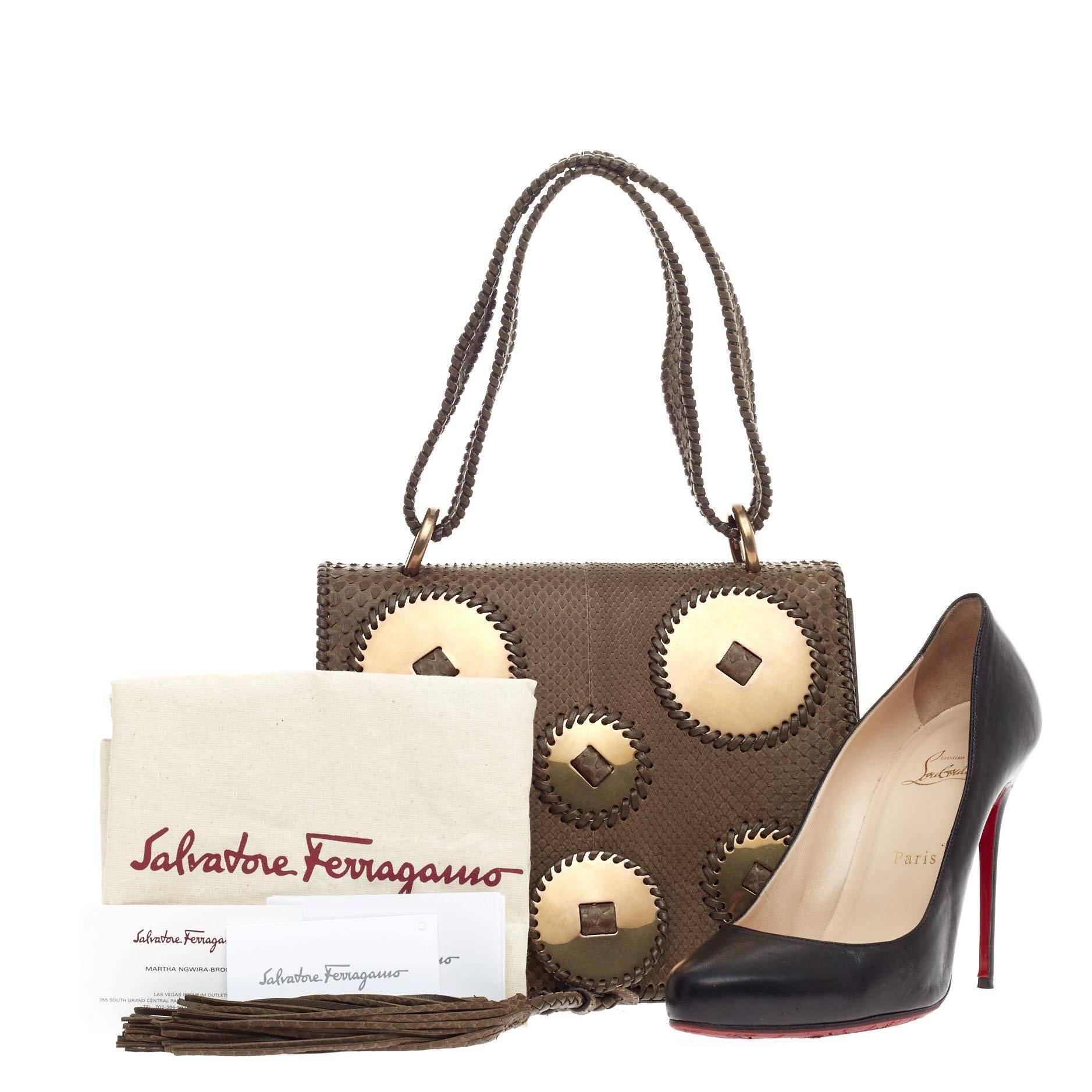 This authentic Salvatore Ferragamo Kamelia Shoulder Bag Python presented in the brand's 2013 Collection mixes a subtle western-inspired design with a luxurious flair. Crafted from brown genuine python skin, this eye-catching full flap bag features