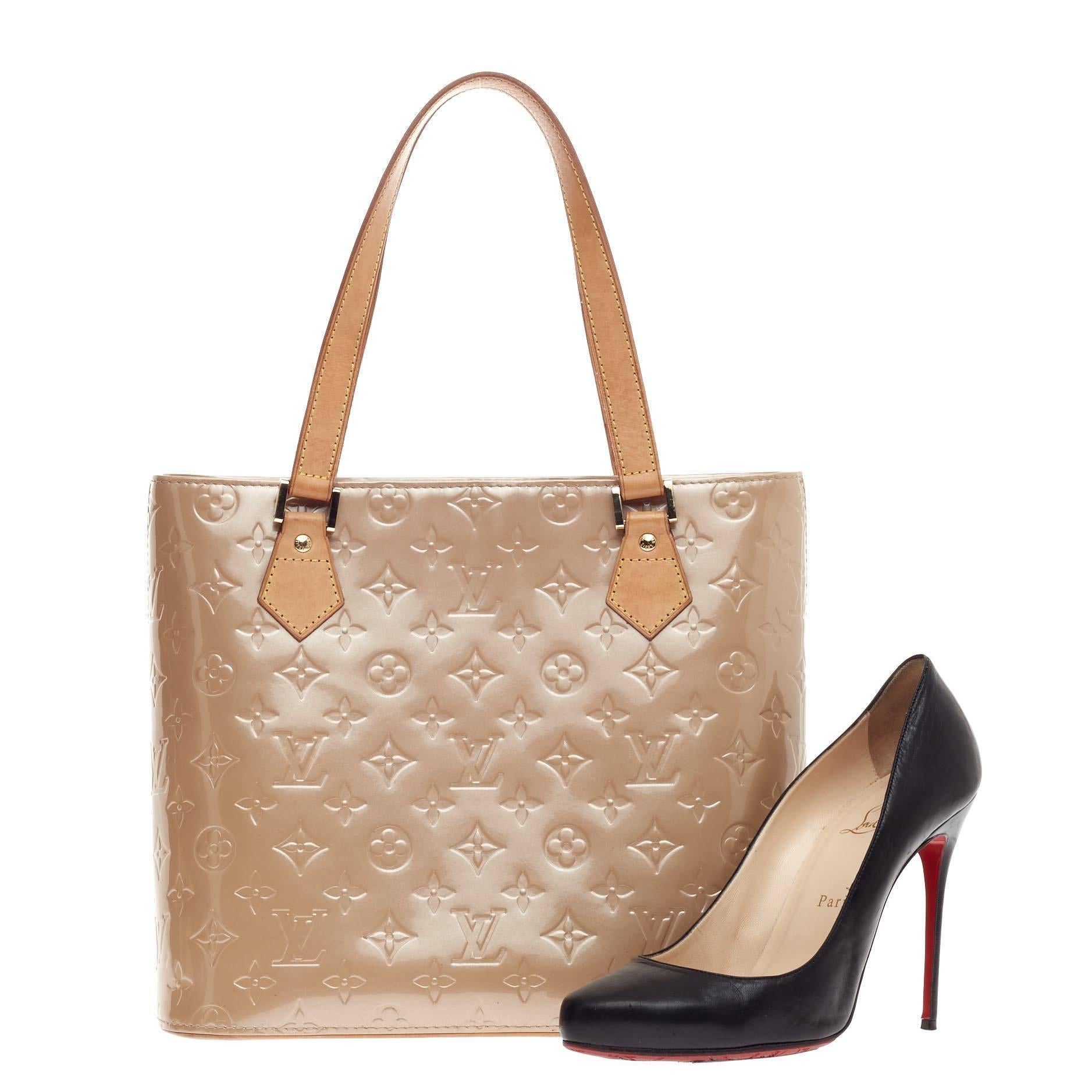 This authentic Louis Vuitton Houston Tote Monogram Vernis is a stylish and functional bag made for everyday use or weekend getaways. Crafted from noisette beige monogram embossed vernis leather, this tote features dual flat tall vachetta leather