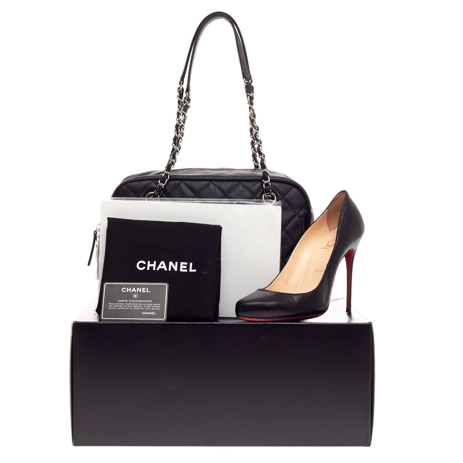 This authentic Chanel Camera Case Flap Bag Quilted Caviar Large presented in the brand's 2014 Collection borrows inspiration from the brand's classic flap bag with a modern twist on its silhouette. Crafted from black caviar leather, this