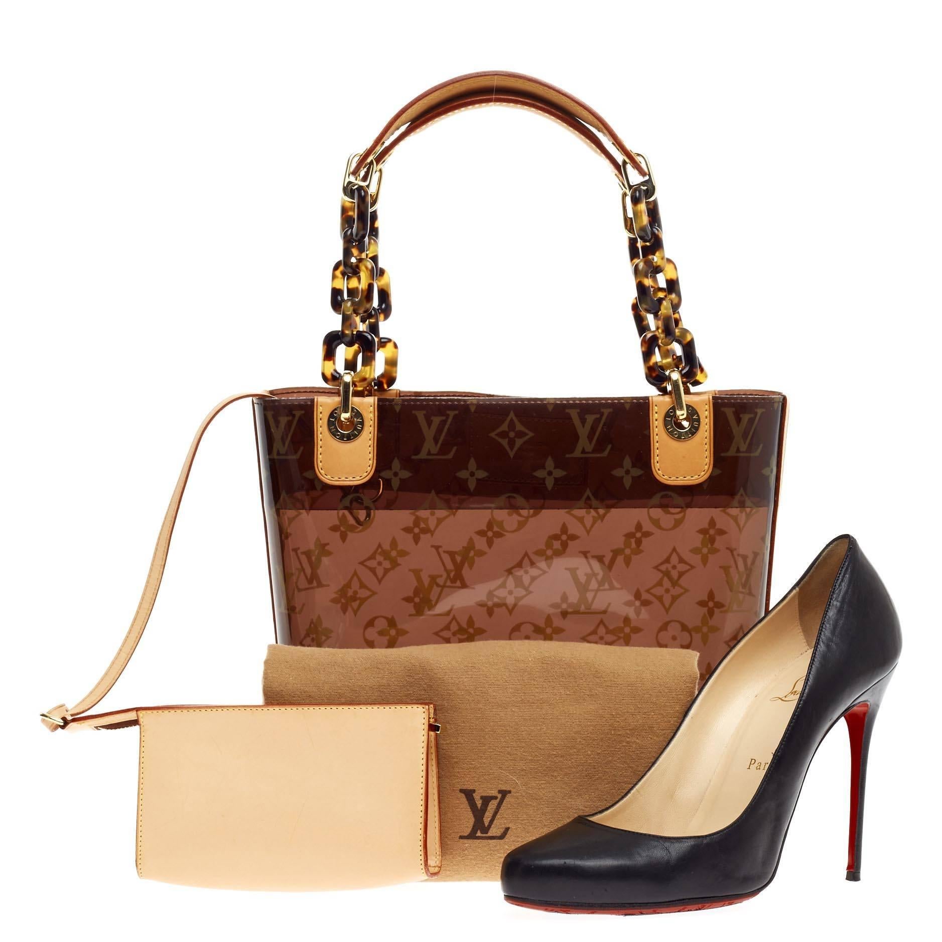 This authentic Louis Vuitton Sac Ambre Monogram Vinyl PM showcases a playful design perfect for casual days. The smallest of Louis Vuitton's Sac Ambre Collection, this petite bag is constructed from monogram printed clear PVC and accented with