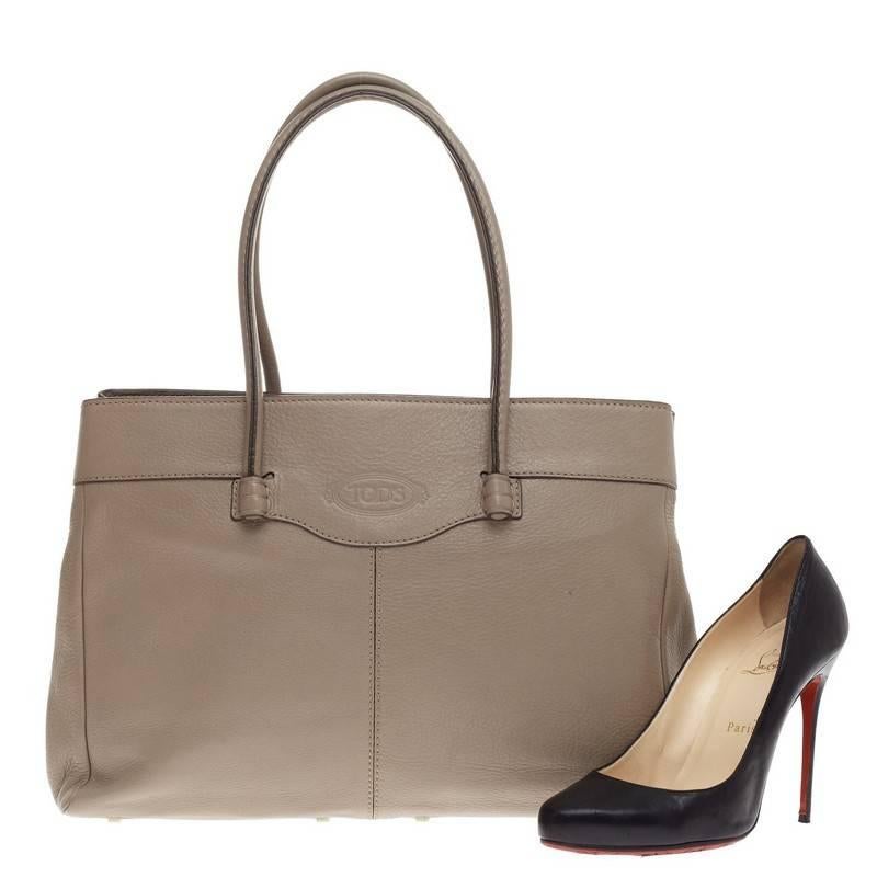 This authentic Tod's Mocassino Tote Pebbled Leather constructed in supple taupe is the perfect accessory for everyday and work excursions. This sturdy, functional bag features dual rolled handles, subtle contrast stitching and protective base studs.