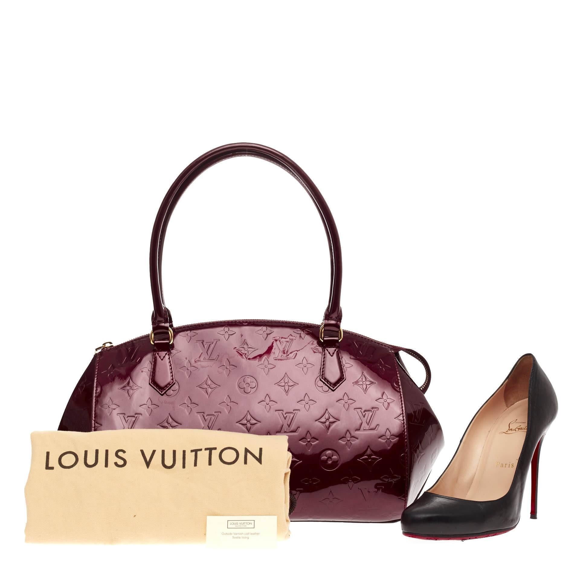This authentic Louis Vuitton Sherwood Monogram Vernis GM is a uniquely shaped bag that showcase a modern take to Louis Vuitton's classic design. Crafted from rouge fauviste red monogram vernis, this structured dome bag features dual-rolled leather