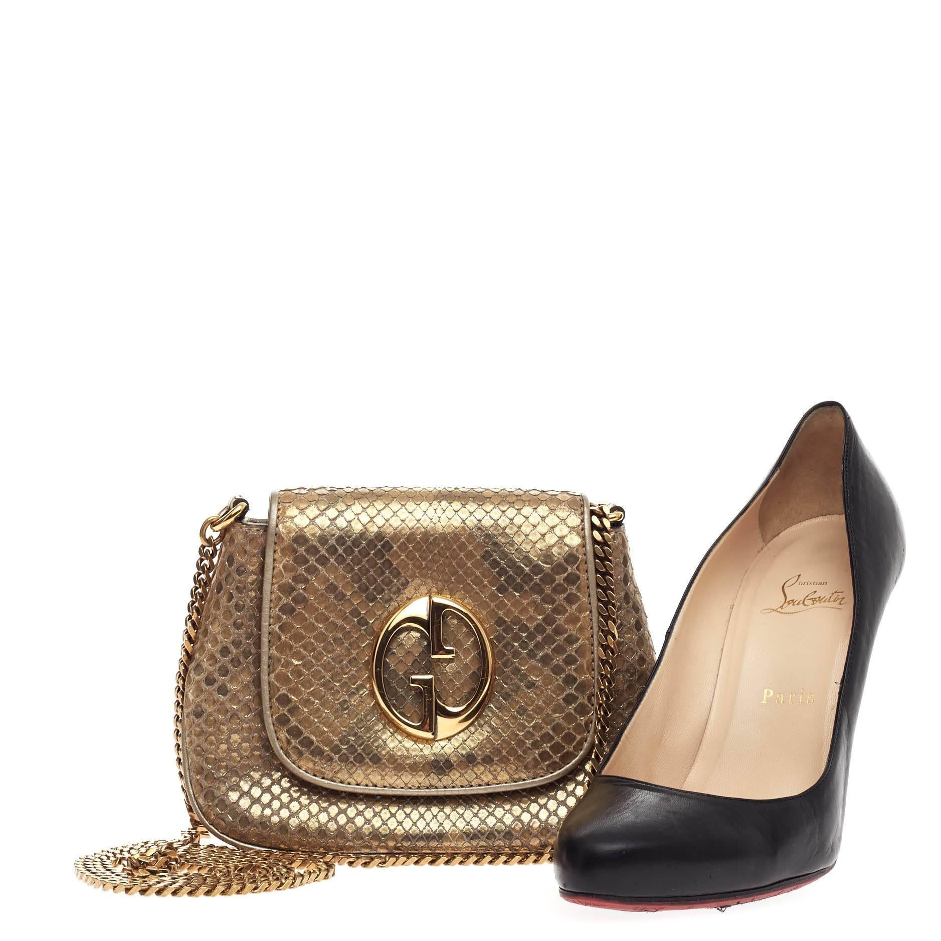 This authentic Gucci 1973 Crossbody Python Small is a classic for Gucci lovers. Crafted from gold genuine python skin, this crossbody features gold  double G detailing on its flap, chain link strap, and gold-tone hardware accent. Its hidden magnetic