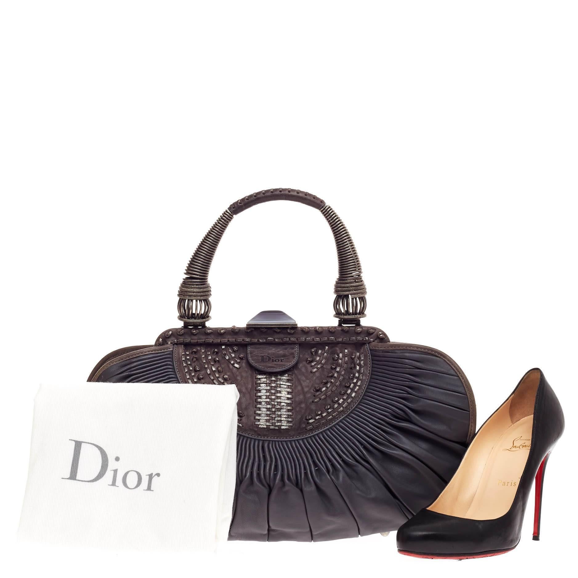 This authentic Christian Dior Plisse Frame Bag Pleated Leather Medium is a statement piece you can surely take from day to night. Crafted from supple gray leather, this ornate accessory features looped top handle with coiled metal detailing and