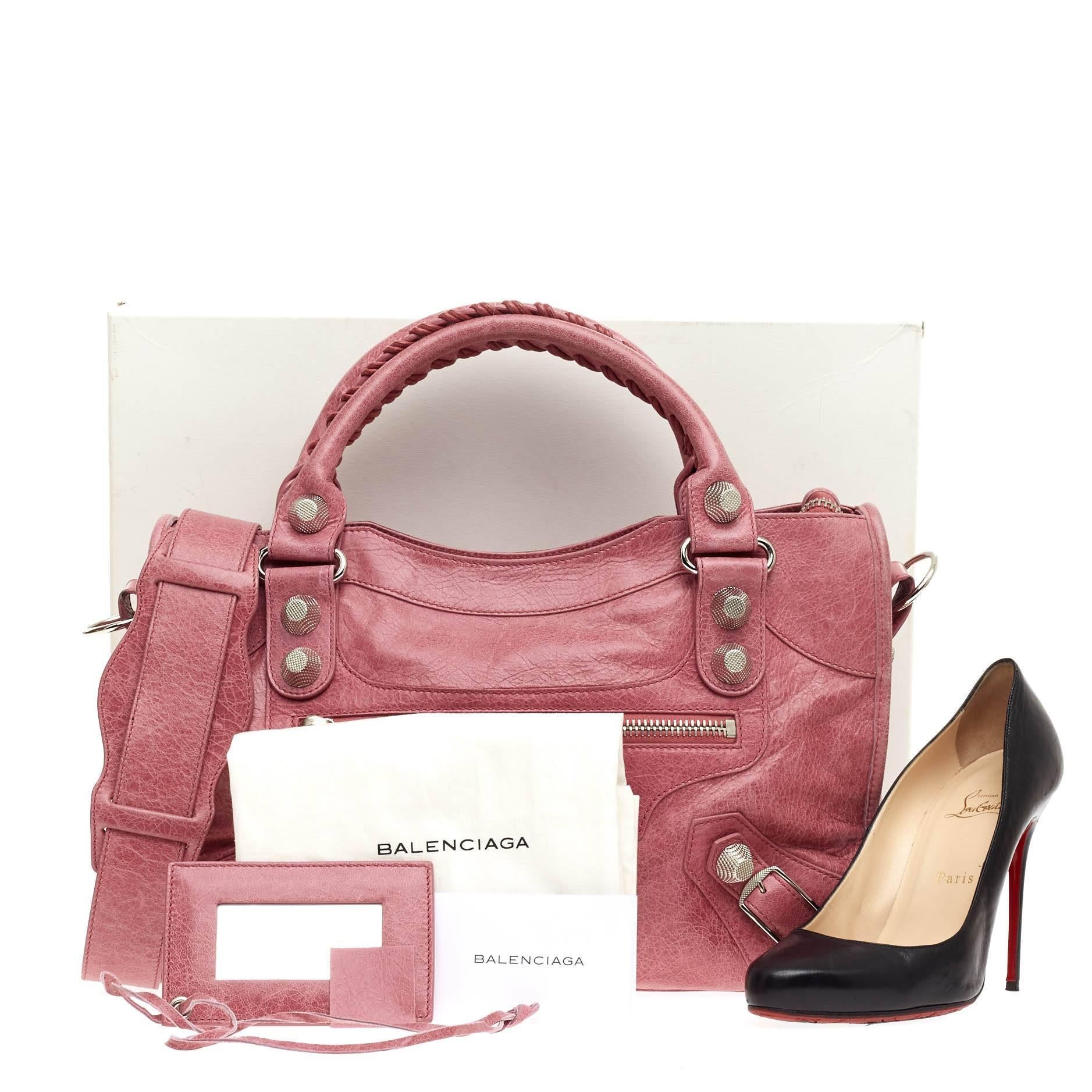 This authentic Balenciaga City Giant Studs Leather Medium is for the on-the-go fashionista. Constructed from bubblegum pink leather, this popular bag features braided woven tall handles, exterior front zip pocket, iconic Balenciaga silver giant