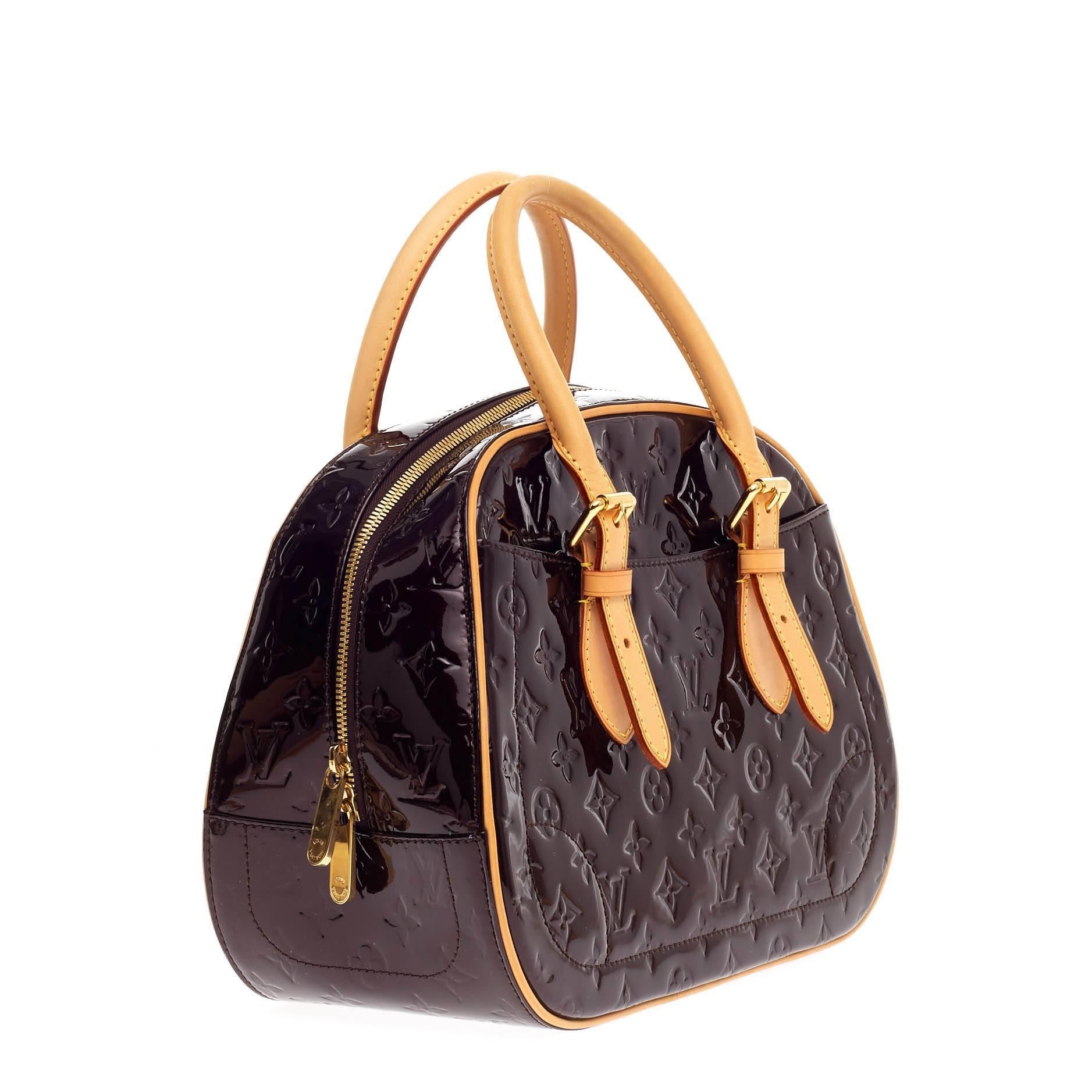 This authentic Louis Vuitton Summit Drive Monogram Vernis is perfect for on the go moments. Crafted in amarante vernis leather, this handbag features dual-flat vachetta leather handles, vachetta leather trims, exterior pockets and gold-tone hardware