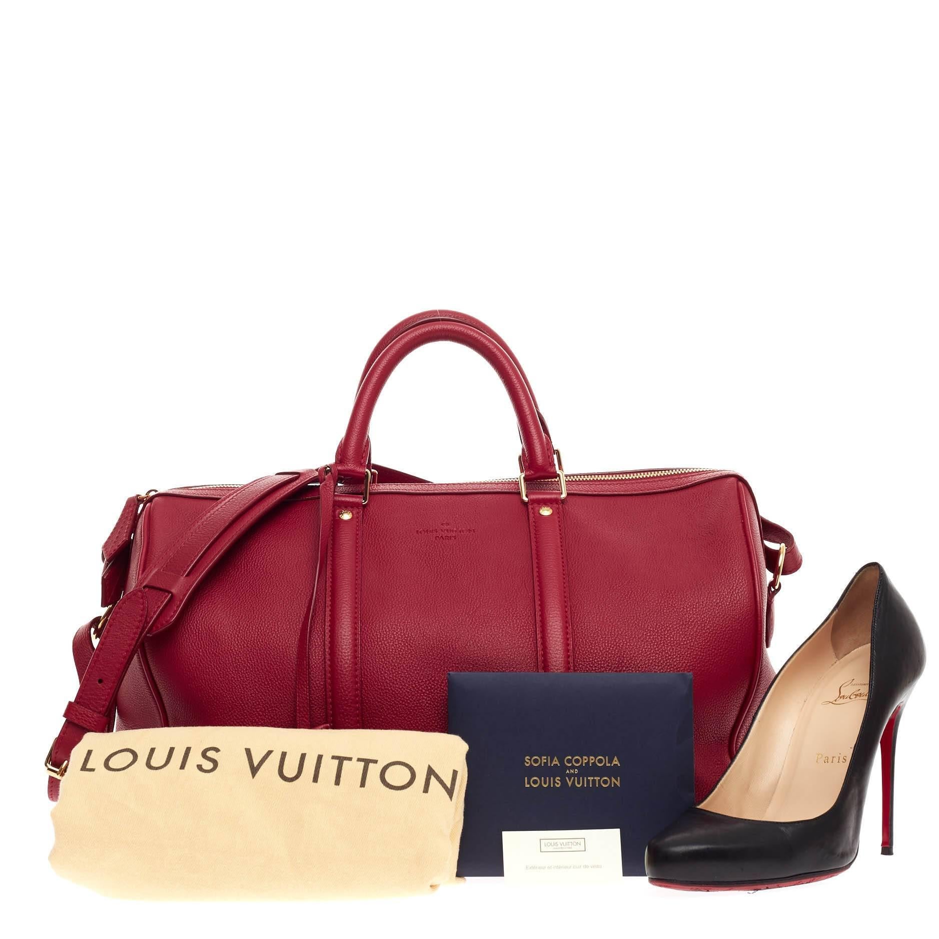 This authentic Louis Vuitton Sofia Coppola SC Bag Leather MM is as stylish and elegant as its designer. Crafted from cherry red grainy leather, this simple yet refined duffle bag features dual-rolled handles, adjustable shoulder strap, LV’s lock and