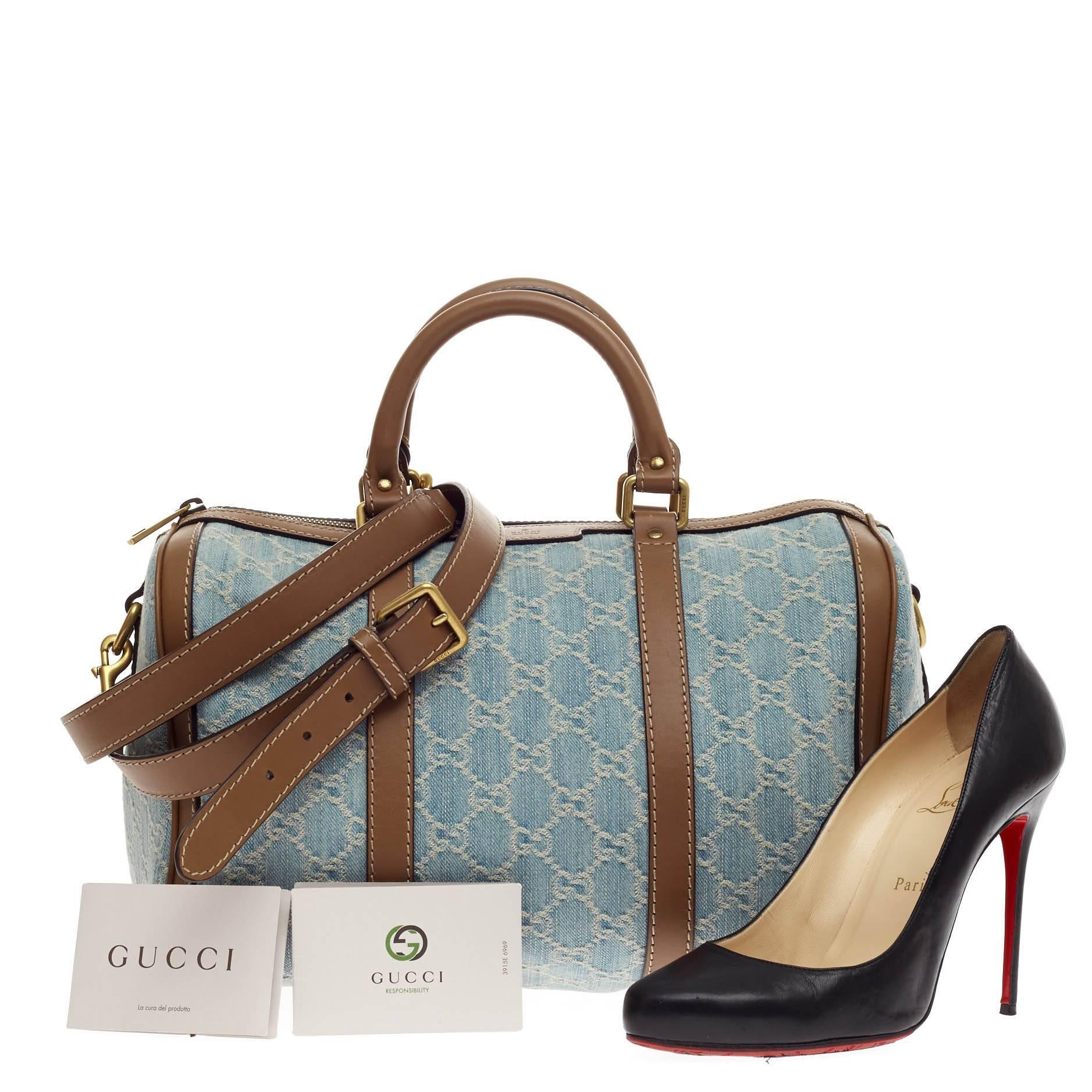 This authentic Gucci Joy Boston GG Denim Medium is a simple and stylish companion perfect for daily excursions. Crafted from washed blue denim GG pattern with brown leather trims, this duffle bag features dual-rolled leather handles, protective base