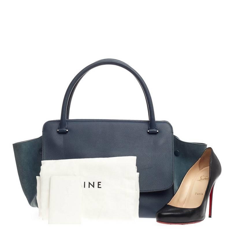 This authentic Celine Double Zip Trapeze Leather is a modern classic featuring a minimalist design. Crafted with blue leather body with matching suede wings, this updated version of Celine's classic trapeze features dual-rolled leather handles, zip