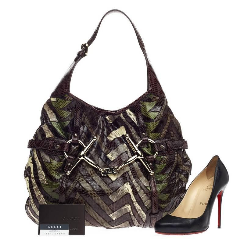 This authentic Gucci Limited Edition 85th Anniversary Python Hobo is a rare and beautiful piece that adds a touch of luxury to any look. Finely crafted from shades of green, brown and cream snakeskin zig-zag patterns, this uniquely designed hobo