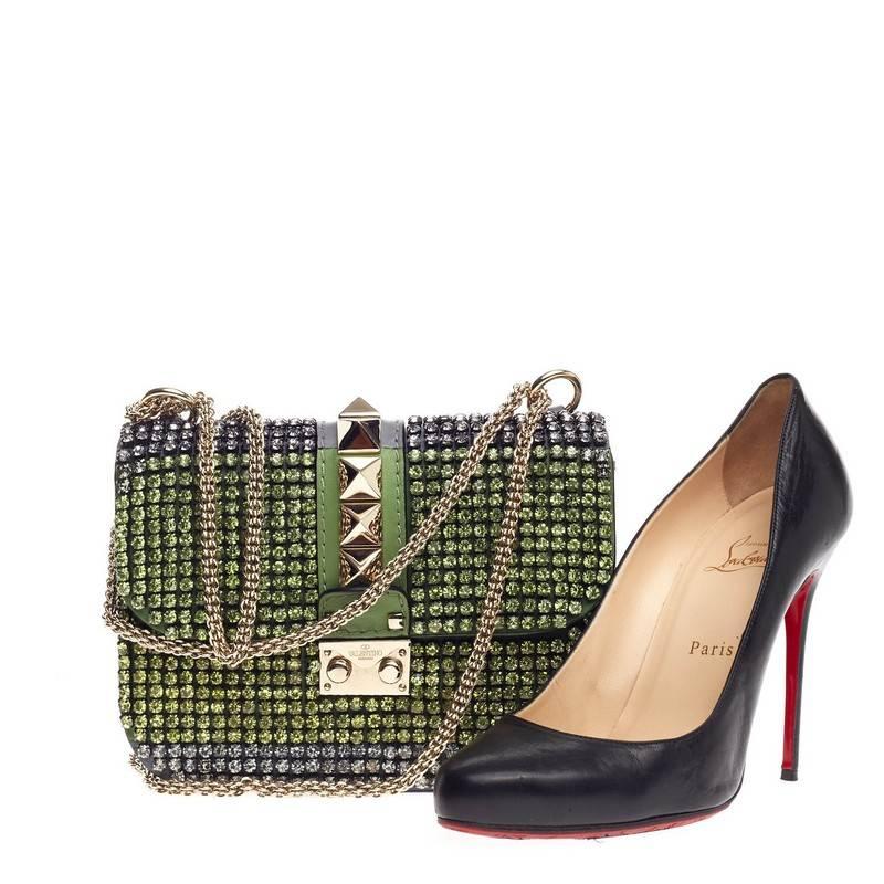 This authentic Valentino Glam Lock Shoulder Bag Crystal Embellished Leather Small is a fun, flirty and feminine accessory perfect for day to night excursions. Crafted in green and silver rhinestones with dark gray leather paneling, this eye-catching