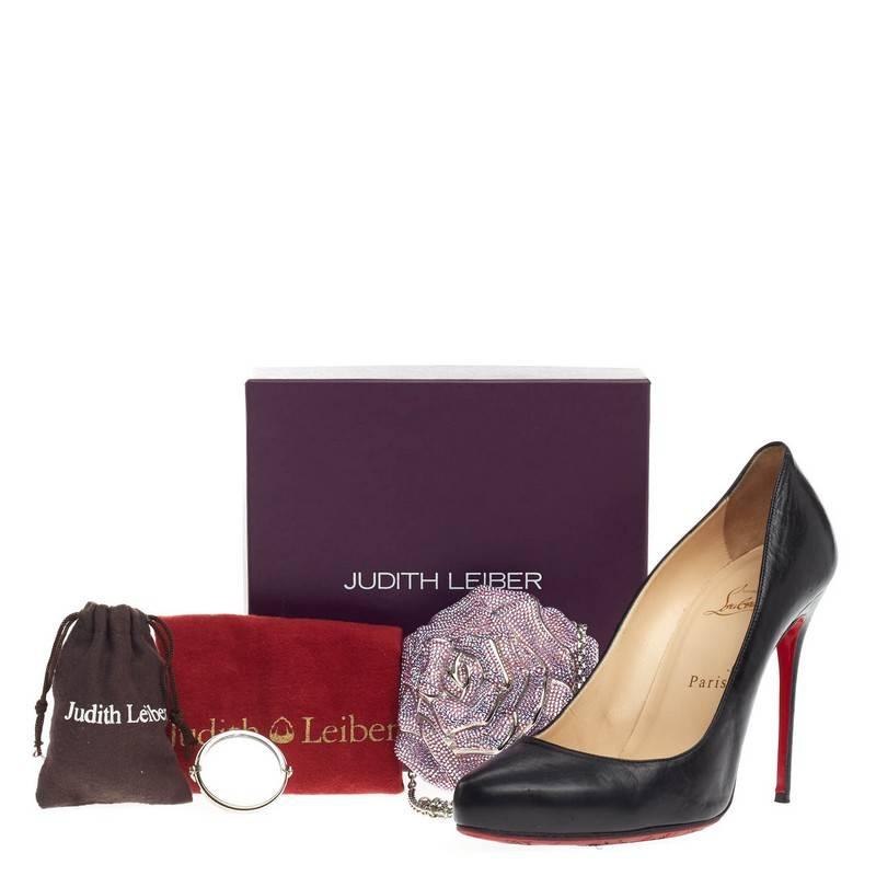 This authentic Judith Leiber Rose Minaudiere Crystal Small inspired by a rose flower is a head-turning, elegant accessory perfect for night outs. Crafted from shimmering vivid pink, purple and green crystals in meticulous design, this hard-shell