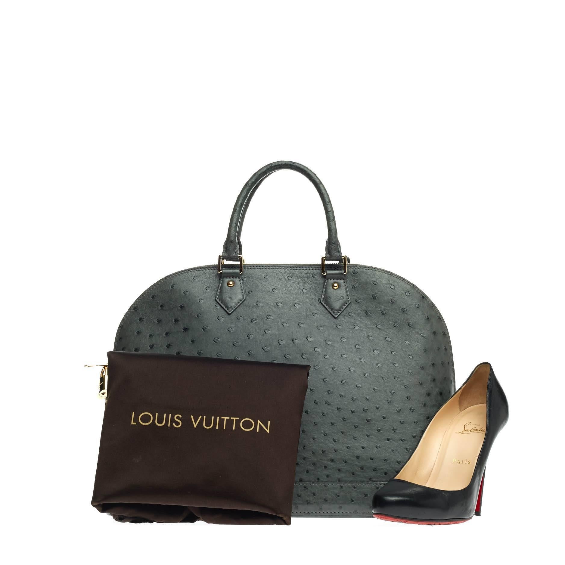 This authentic Louis Vuitton Alma Ostrich GM is a timeless piece made for anyone with impeccable taste. Crafted from genuine gris grey ostrich skin, this dome-like bag features dual-rolled ostrich leather handles, protective base stud and gold-tone