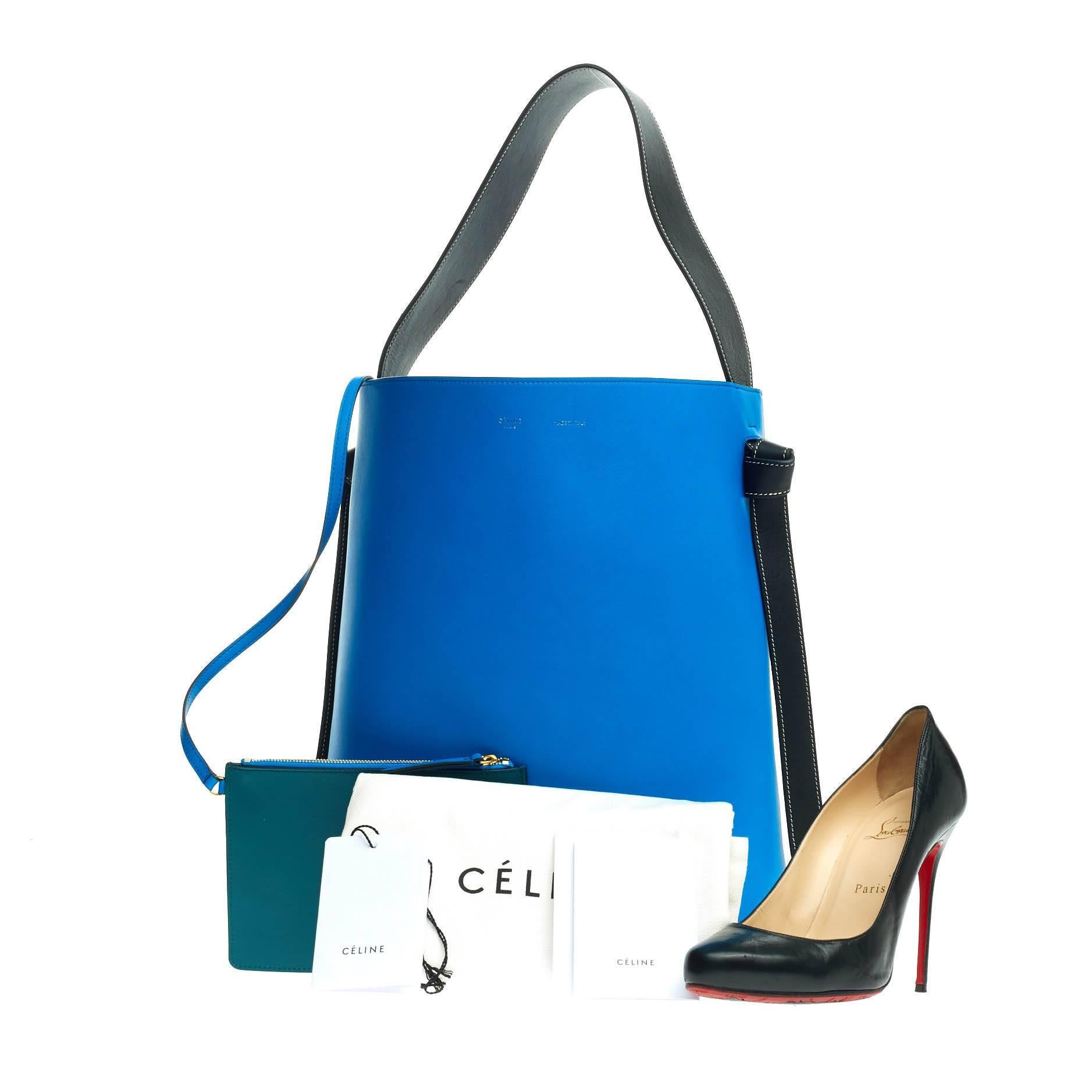 This authentic Celine Twisted Cabas Tote Calfskin Small presented from the brand's Spring 2016 is a minimalist, youthful accessory made for everyday excursions. Crafted from bright blue and peacock green calfskin leather, this fresh tote features