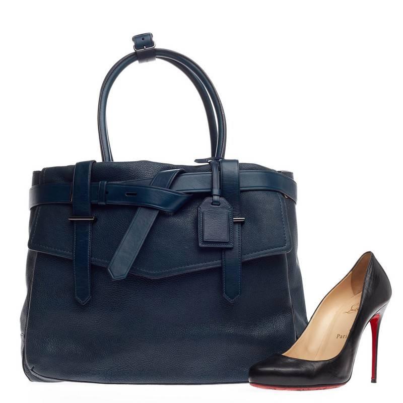This authentic Reed Krakoff Boxer Tote Leather Large is a versatile structured bag with an added pop of color for a playful twist. Constructed from very dark teal leather, this functional tote features wrap-around leather buckle strap detailing on