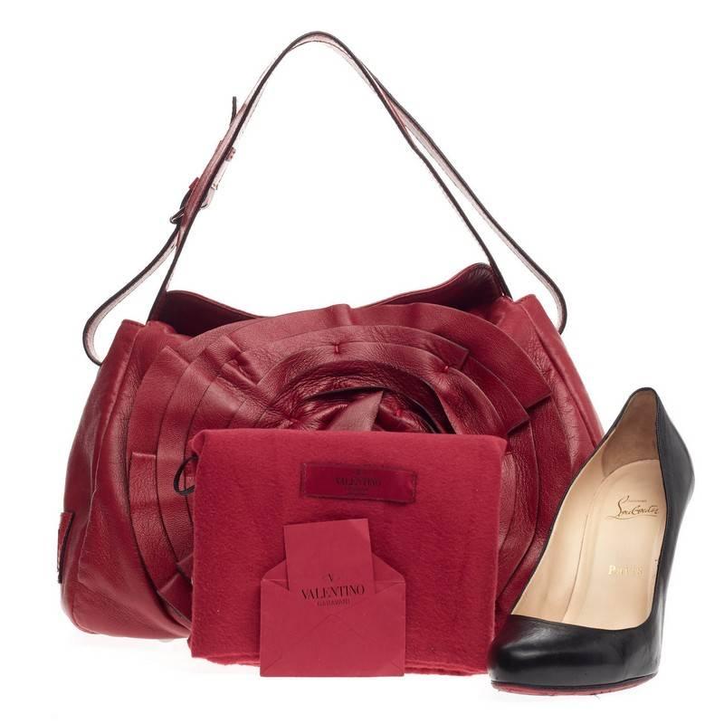 This authentic Valentino Petale Flap Shoulder Bag Leather stylishly combines a casual silhouette with romantic motifs characteristic of Valentino's designs. Crafted from supple rouge red leather, this feminine bag features adjustable buckled