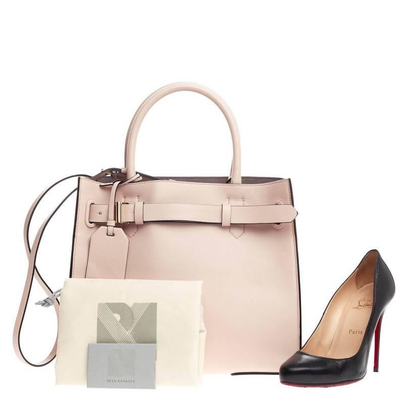 This authentic Reed Krakoff RK40 Tote Leather Medium is a versatile, structured bag that complements both dressy and casual looks. Crafted from pale pink leather, this minimalist tote features dual-rolled handles, stand-out contrast black leather