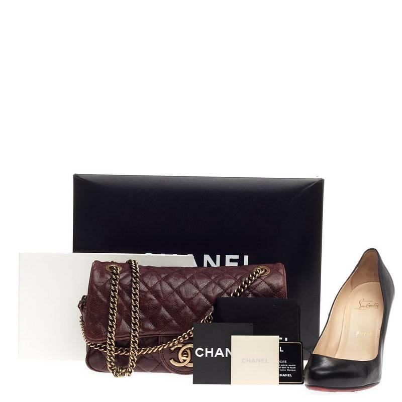 This authentic Chanel Shiva Flap Bag Quilted Caviar Medium presented in the brand's Pre-Fall 2012 Paris-Bombay Collection showcases classic Chanel style with a modern twist. Crafted in raspberry diamond quilted caviar leather, this modern, durable