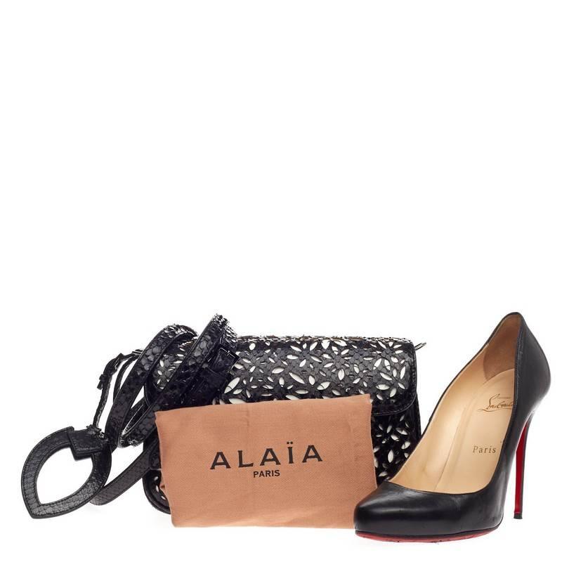 This authentic Alaia Symmetrical Flap Bag Laser Cut Python Small personifies the brand's quintessential chic style with exotic edge. Constructed in white leather and black genuine python skin with a beautiful floral laser cut design, this