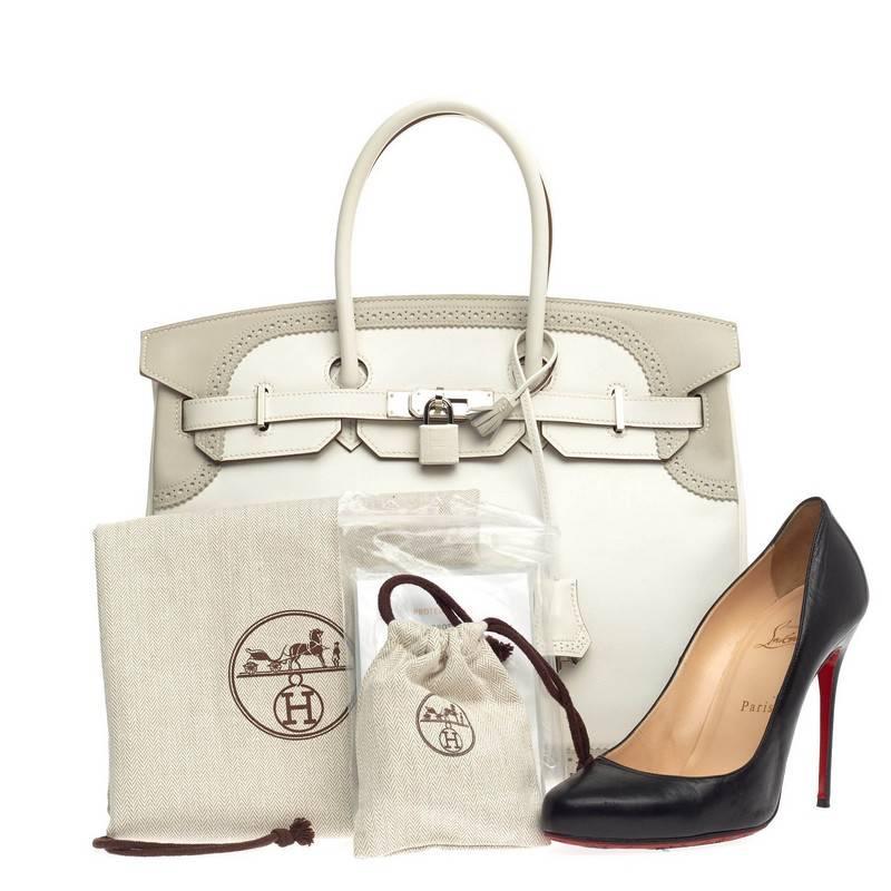 This authentic Hermes Birkin Ghillies White and Gray Swift with Palladium Hardware 35 is a special edition piece that graces only a few closets. Crafted from white and gris perle grey swift leather, this coveted Birkin features dual-rolled handles,
