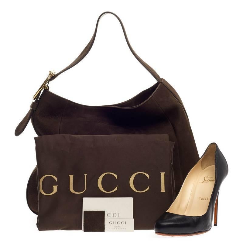 This authentic Gucci Ribot Horse Heads Hobo Nubuck Large is perfect for everyday use. Crafted from dark brown nubuck leather, this traditionally-shaped hobo features flat shoulder strap with double horse head buckle embellishment and gold-tone