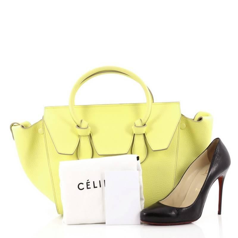 This authentic Celine Tie Knot Tote Grainy Leather Mini presented in the brand's Spring/Summer 2014 Collection is an absolute must-have for serious fashionistas. Crafted from neon yellow grainy leather, this boxy, chic tote features dual-rolled