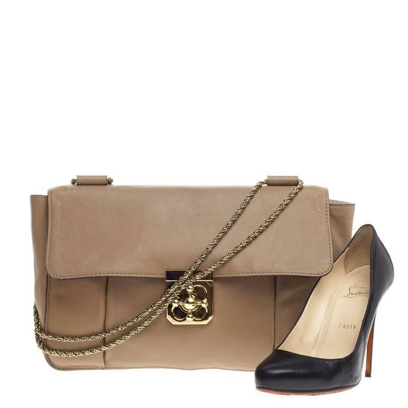 This authentic Chloe Elsie Chain Shoulder Bag Leather Large is a unique piece perfect for day to night outs. Crafted from taupe leather, this stand-out flap bag features short twisted gold-tone chain straps and decorative gold-tone rotating floral